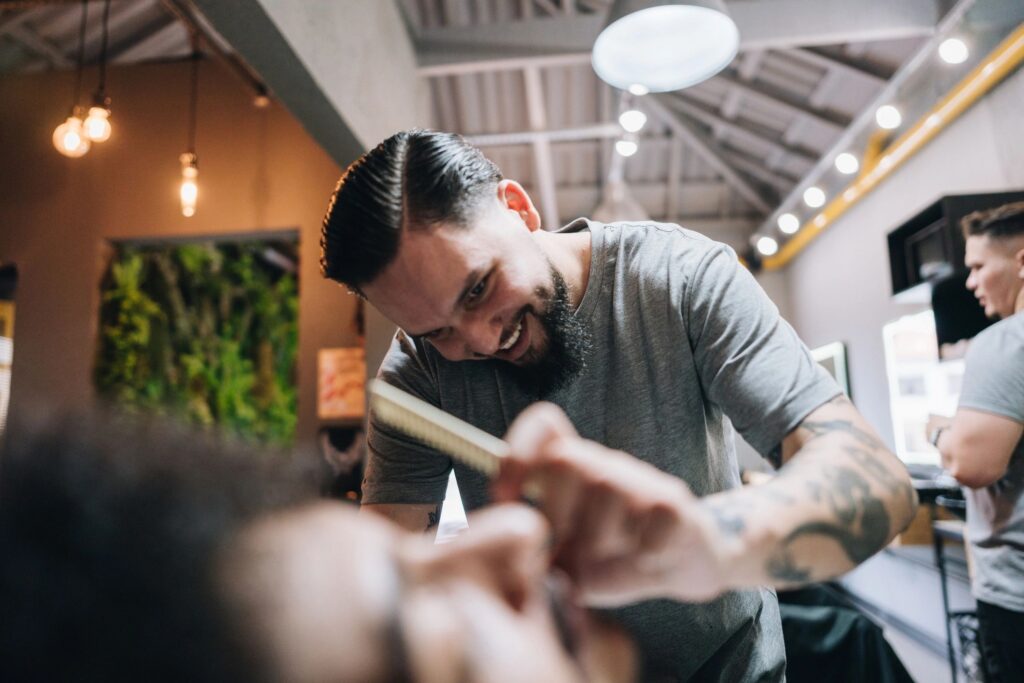 Barber shaving customer's beard in a barber shop